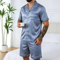 Homme debout en pyjama en soie homme short rayé bleu, chemise manches courtes et short assorti