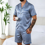 Homme debout en pyjama en soie homme short rayé bleu, chemise manches courtes et short assorti